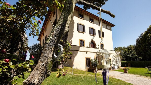 Un bâtiment à deux étages doté d’un jardin, d’un belvédère et d’une statue.