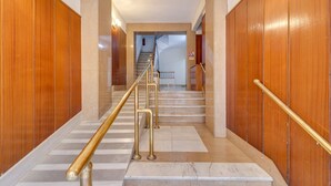 A hallway with marble steps, wooden paneling, and a staircase leading to another floor. - GuestReady - Charming Studio with Patio in Gràcia (Barcelona)
