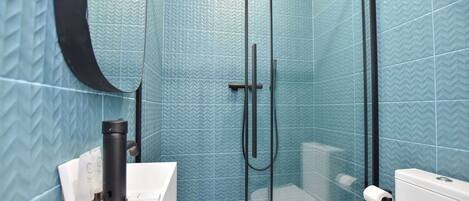 Un baño con ducha, inodoro y lavamanos.