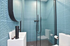 Un baño con ducha, inodoro y lavamanos.