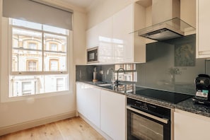 Eine moderne Küche mit großem Fenster, eingebauter Mikrowelle und Geschirrspüler.
