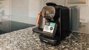 Eine Kaffeemaschine mit einem Aufkleber, der angibt, dass sie für Bio-Kaffeekapseln geeignet ist.