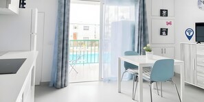 A modern hotel room with a balcony, a dining area, and a TV. - Vacation Apartment 'B-rent San Valentin Little Dreams' with Shared Pool, Private Terrace and Wi-Fi (Corralejo)
