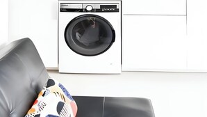 Une cuisine compacte équipée d’un lave-linge, d’un four à micro-ondes et d’un évier.
