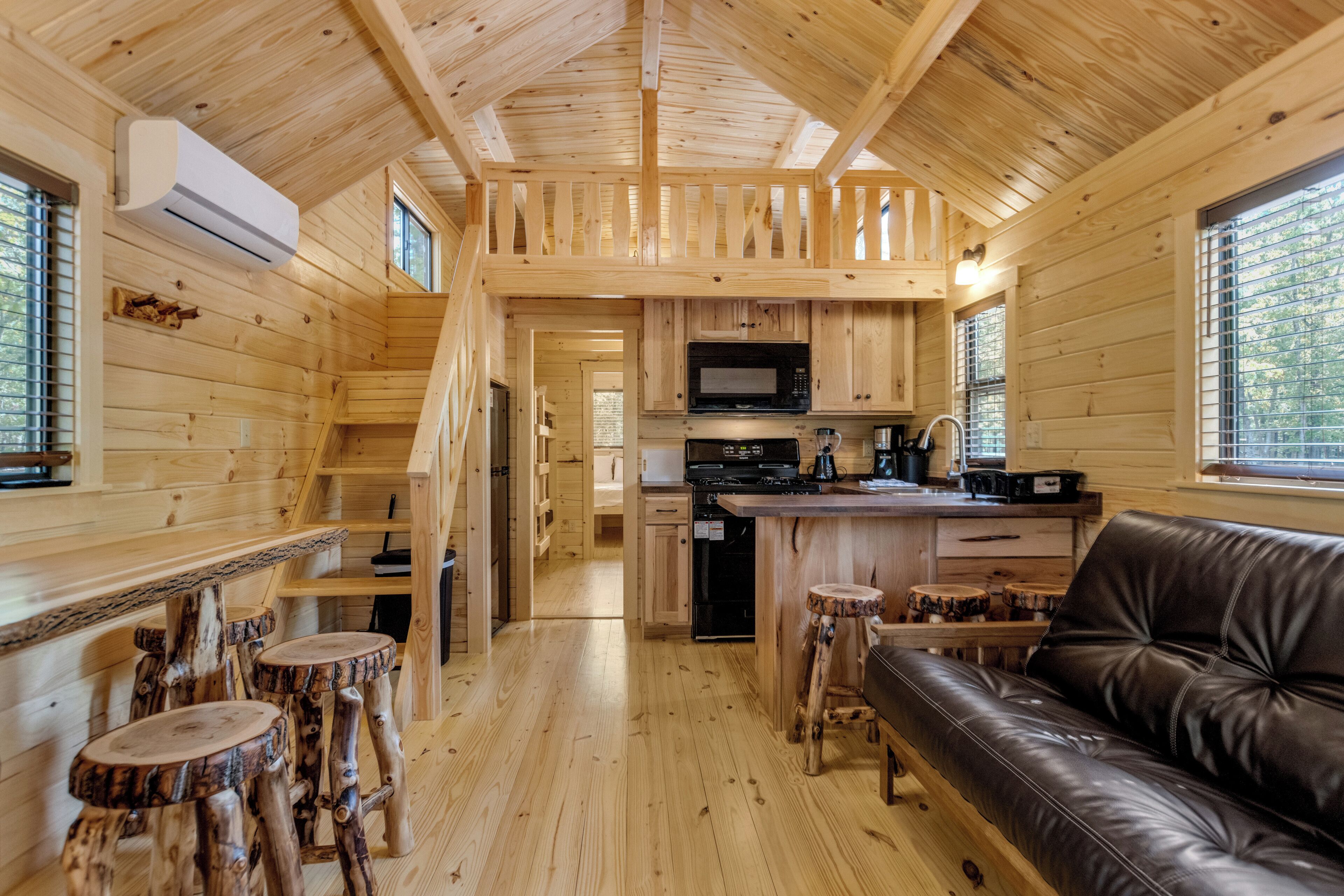 Interior de una cabaña con cocina, comedor y sala de estar.