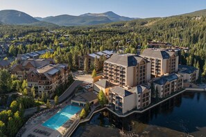 Un resort con varias edificaciones, una piscina y un lago.