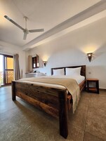 Ein Schlafzimmer mit einem hölzernen Bett, einem Deckenventilator und zwei Wandleuchten.