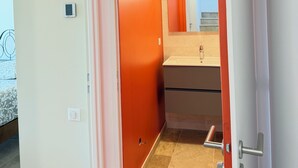 Ein Hotelzimmer mit Bett, einem Badezimmer mit Spiegel und einer Tür zu einem weiteren Raum.