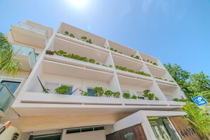 A multi-story building with balconies, some with plants. - Luxury apartment with pool & high speed WIFI (Playa del Carmen)