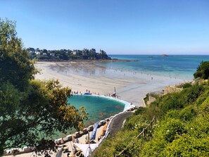 A coastal beach with a clear view of the sea, a swimming pool, and a stone pathway leading to the beach. - Pleurtuit, a luminous green haven (Pleurtuit)