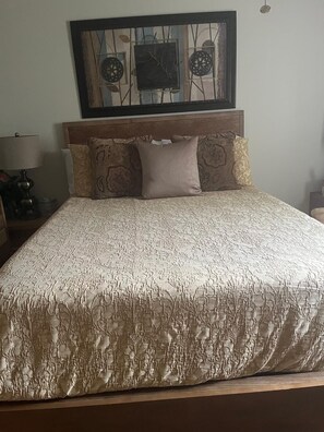 A bed with a patterned bedspread, a headboard, and decorative pillows. - Clean & Cozy Room with Private Bath. Minutes to Disney. Free parking. (Kissimmee)
