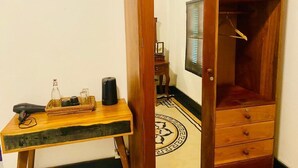 Un meuble en bois avec un miroir, une petite table sur laquelle se trouve un plateau contenant divers objets, et un sol à motifs.