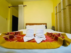 Una habitación de hotel con cama, cortina y ventana con cortinas.