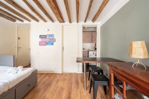 Una camera da letto con un letto, una scrivania, una sedia e una lampada.