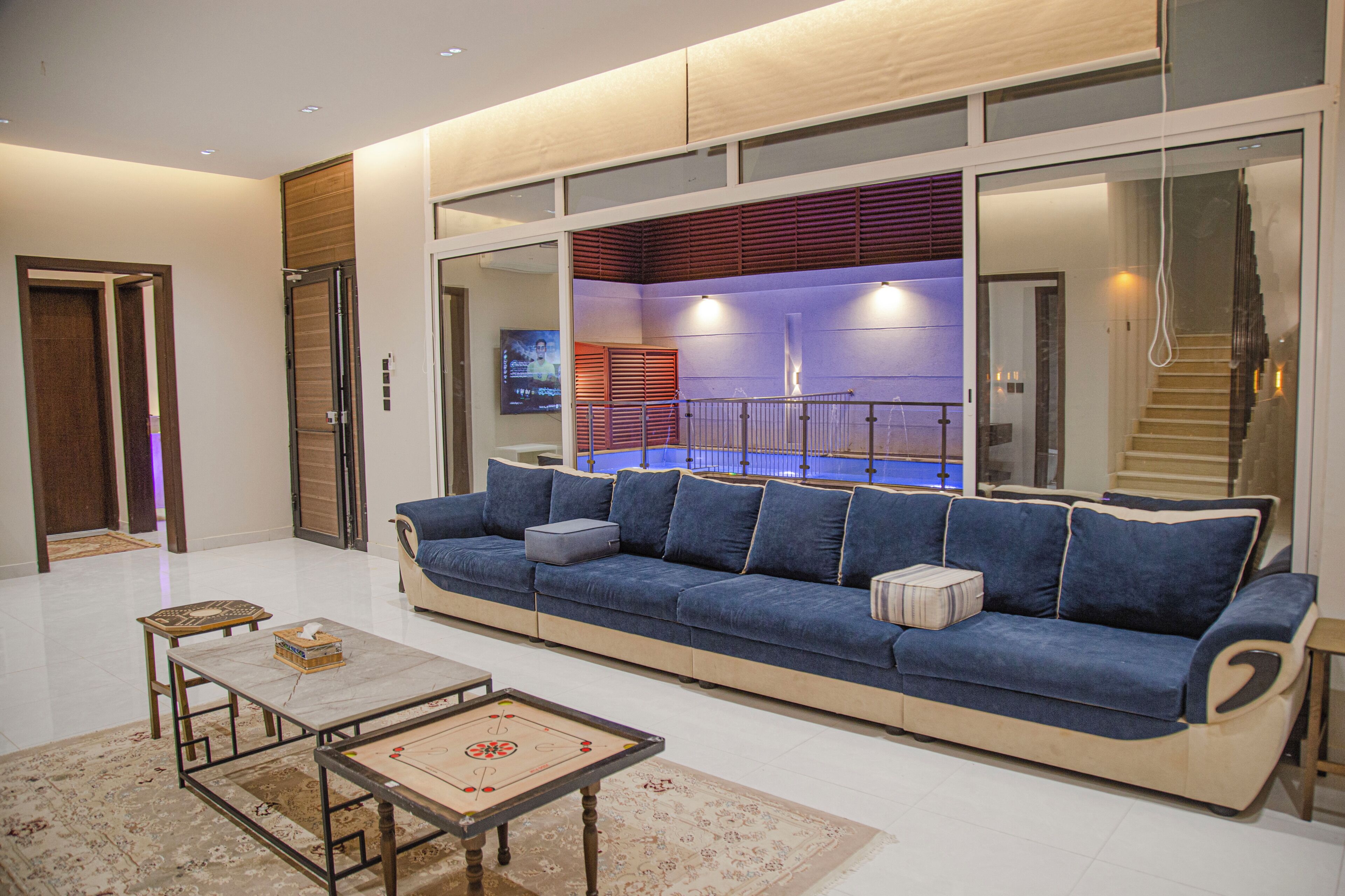 Un salon moderne avec un canapé bleu, une table basse et un téléviseur.