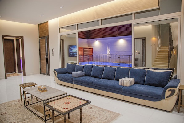 Un salon moderne avec un canapé bleu, une table basse et un téléviseur.