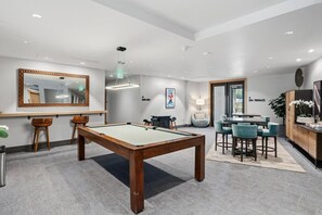 A modern indoor pool table with a bar area, seating, and a large mirror. - Riverfront Lodge Condo W/Resort Amenities (Avon)