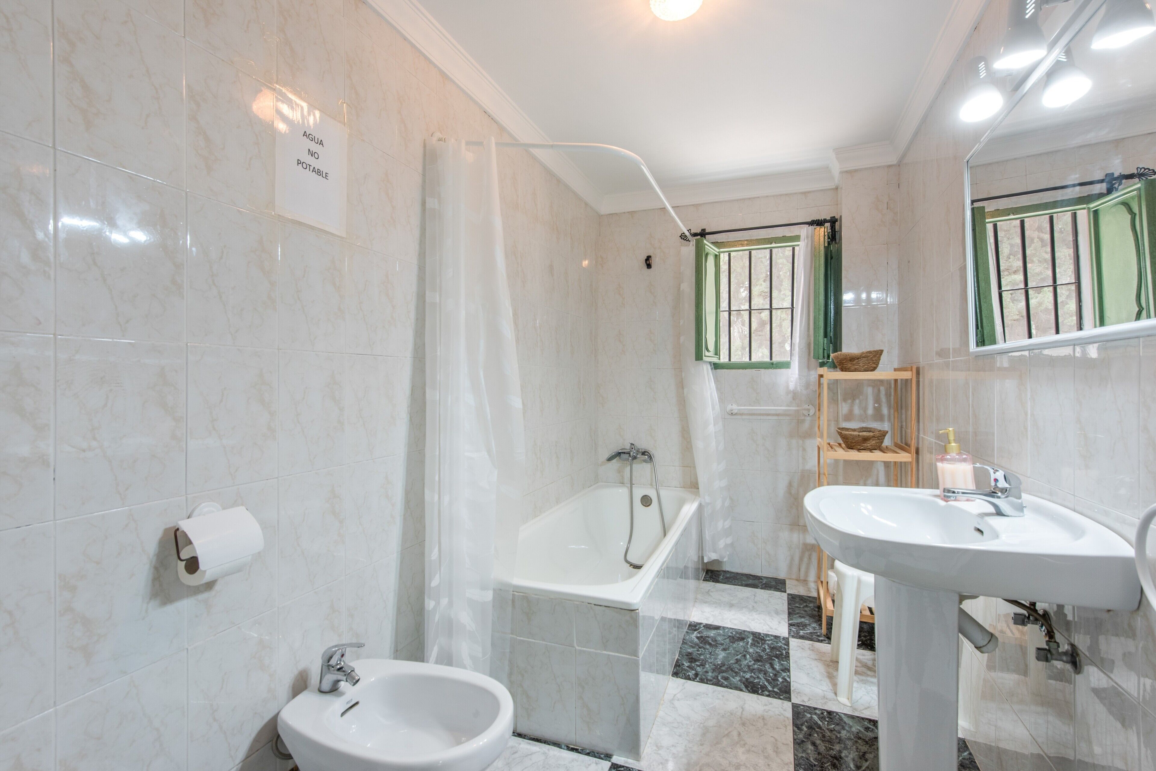 Un baño con bañera, bidé y lavabo.