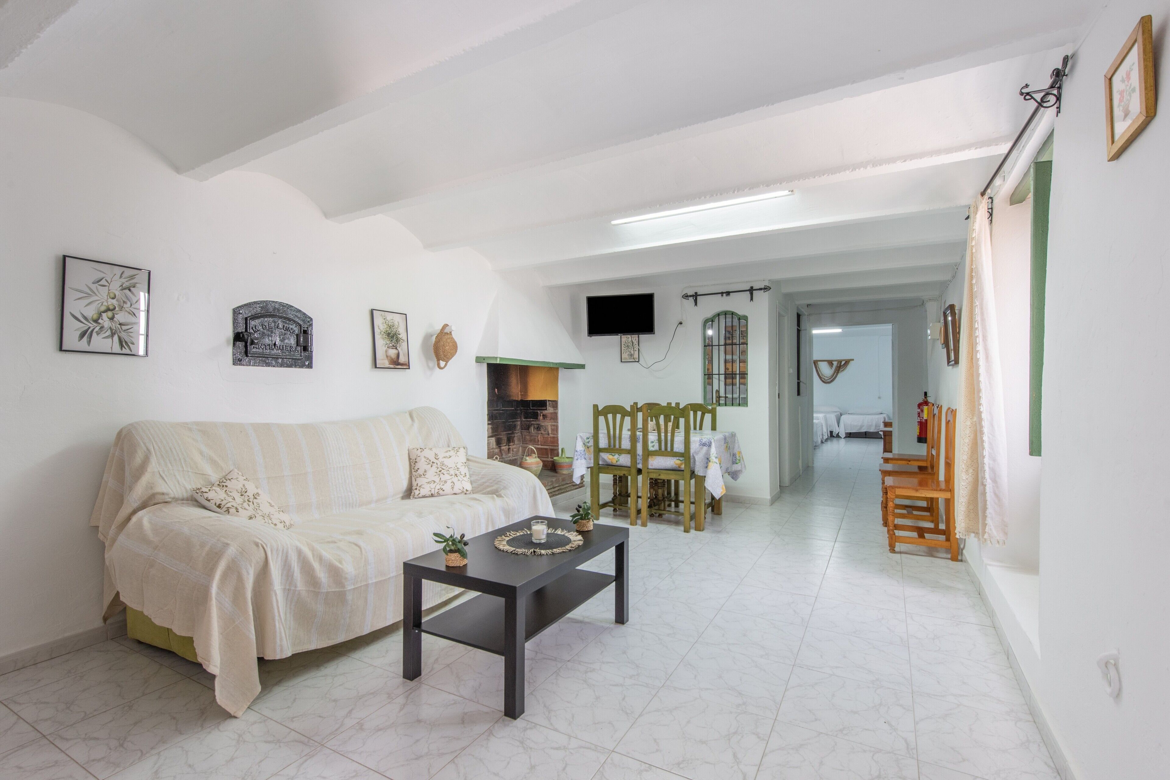 Una sala de estar con sofá, mesa de centro y chimenea.