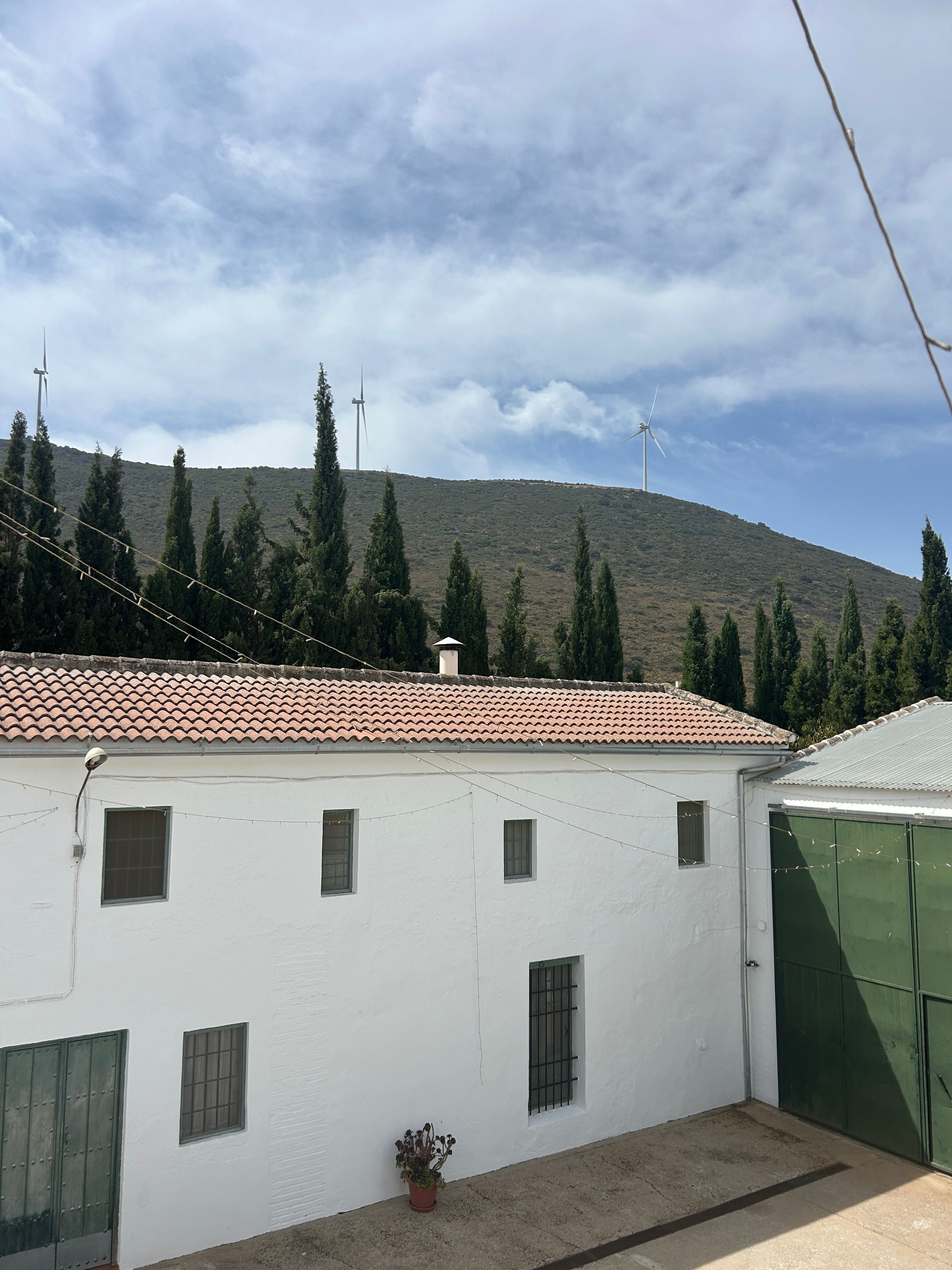 Un edificio blanco con tejado de baldosas, varias ventanas y una puerta verde.