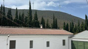 Un edificio blanco con tejado de baldosas, varias ventanas y una puerta verde.