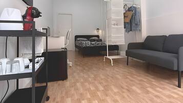 Una camera moderna con un letto, un divano, una scrivania e un port scarpe.