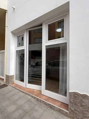 Ein Gebäude mit weißer Fassade, einem sichtbaren Fenster und einem steinernen Sockel.