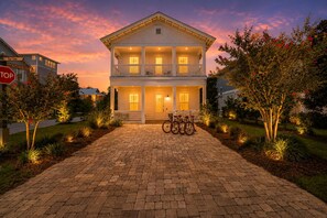 A two-story building with a front porch, a stop sign, and a bicycle parked in front. - Beauty and The Beach by Stay on 30a (Inlet Beach)