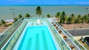 A rooftop pool with a clear view of the beach and ocean. - Located across from Cabo Branco Beach - Apartment with ocean view. (João Pessoa)