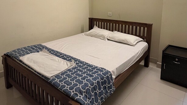 Un dormitorio con cama, ventilador de techo y mesita de noche.