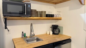Cocina compacta con microondas, cafetera y lavavajillas.