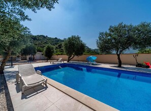 A swimming pool with lounge chairs and a blue umbrella. - Natur Olive House Ston (Ston)