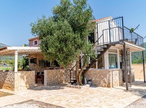 A two-story building with a stone facade, a covered patio, and a staircase leading to an upper level. - Natur Olive House Ston (Ston)
