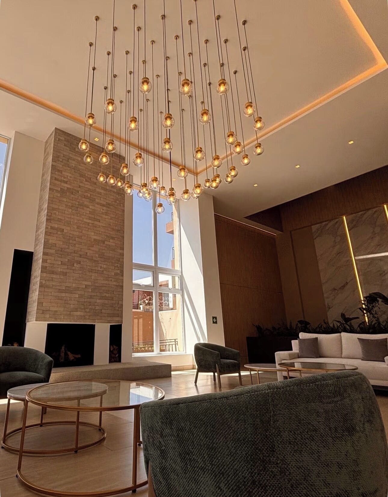 Un intérieur moderne agrémenté d’un luminaire suspendu, d’une cheminée et d’un espace salon.