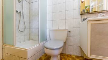 Une salle de bain avec une douche, des toilettes et un lavabo.
