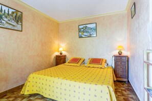 Un dormitorio con una cama, dos mesitas de noche y dos lámparas de pared.