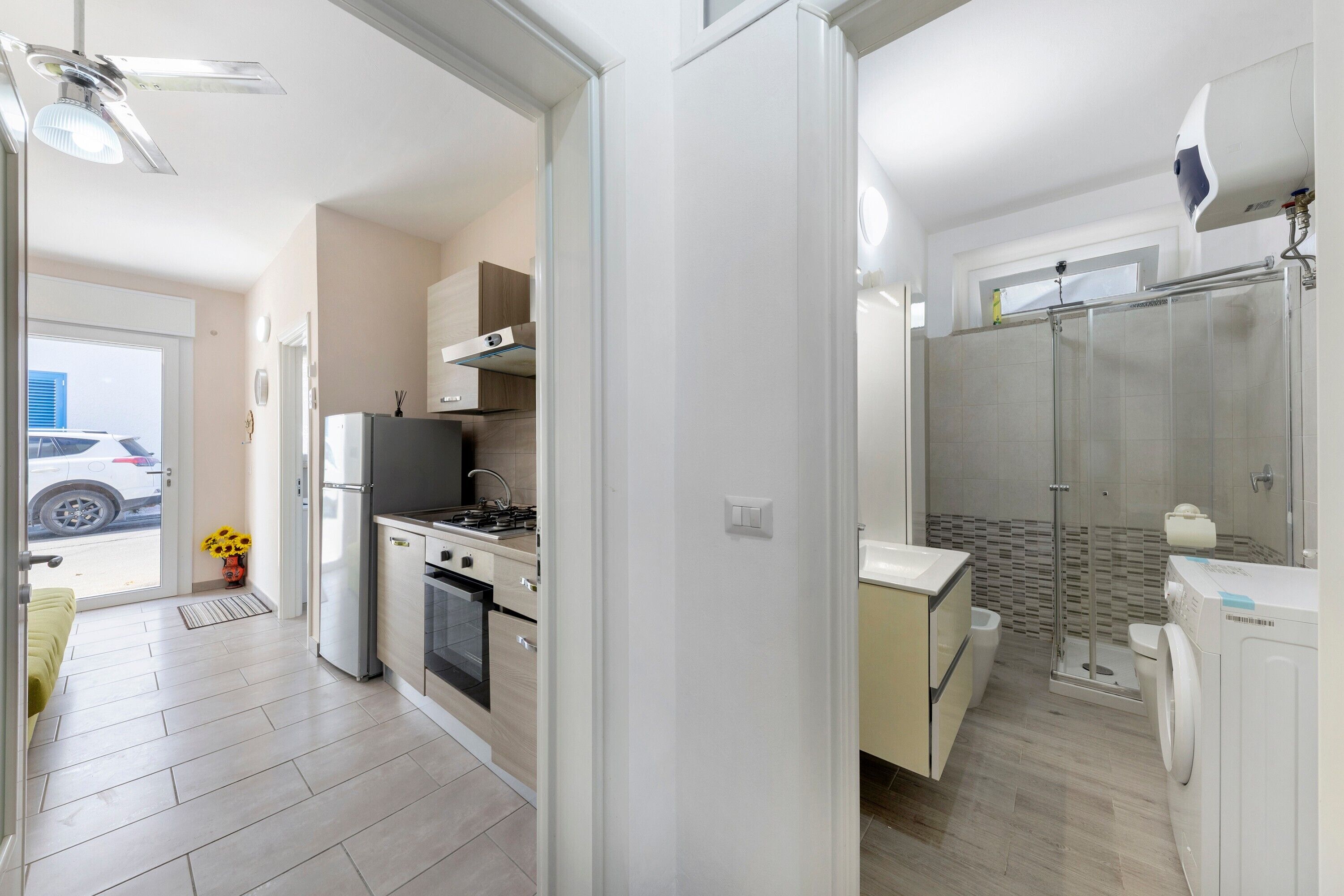 Eine moderne Küche mit Einbauofen und Herd, ein Essbereich mit Tisch und Stühlen sowie ein separates Badezimmer mit Dusche und Toilette.