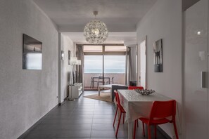 Ein modernes Interieur mit Essbereich, Blick aufs Meer und einer Kristallleuchter.