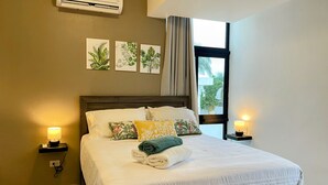 Ein Hotelzimmer mit einem Bett, einer wandmontierten Klimaanlage und einem Fenster mit Vorhängen.