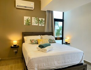 A hotel room with a bed, wall-mounted air conditioner, and a window with curtains. - Relaxing 3BR Escape  Private Jacuzzi & BBQ (Punta Cana)