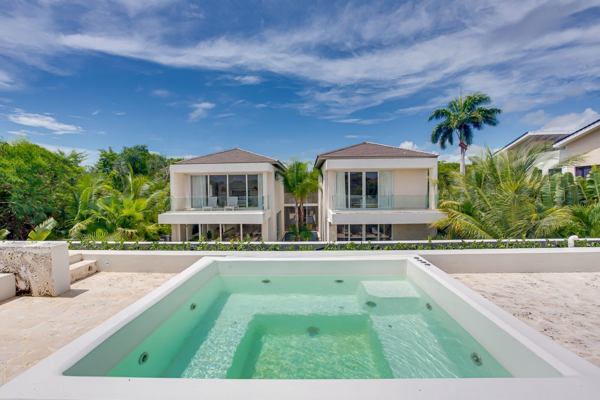 A modern two-story house with a swimming pool in the foreground.
