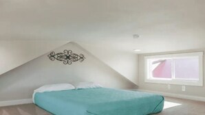 Ein Schlafzimmer mit einem Bett, einem Fenster und einem Wandbild.