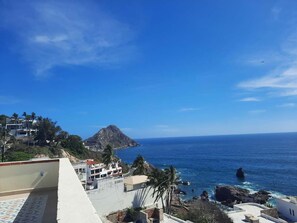 Blick auf die Küste mit Gebäuden, einem Berg und dem Meer.