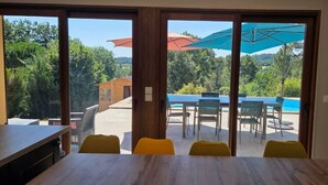 Un área de comedor con vistas a una piscina y mobiliario exterior.