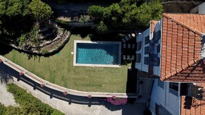 An aerial view of a property with a swimming pool, a garden, and a building with a tiled roof. - Villa Apolline · 1892 Estate · 5 BR, Heated Pool, Riviera Views (Grasse)