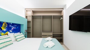 A hotel room with a bed, a large wardrobe, a flat-screen TV, and a painting on the wall. - Apartment in Las Palmas Near Las Canteras Beach (Las Palmas de Gran Canaria)