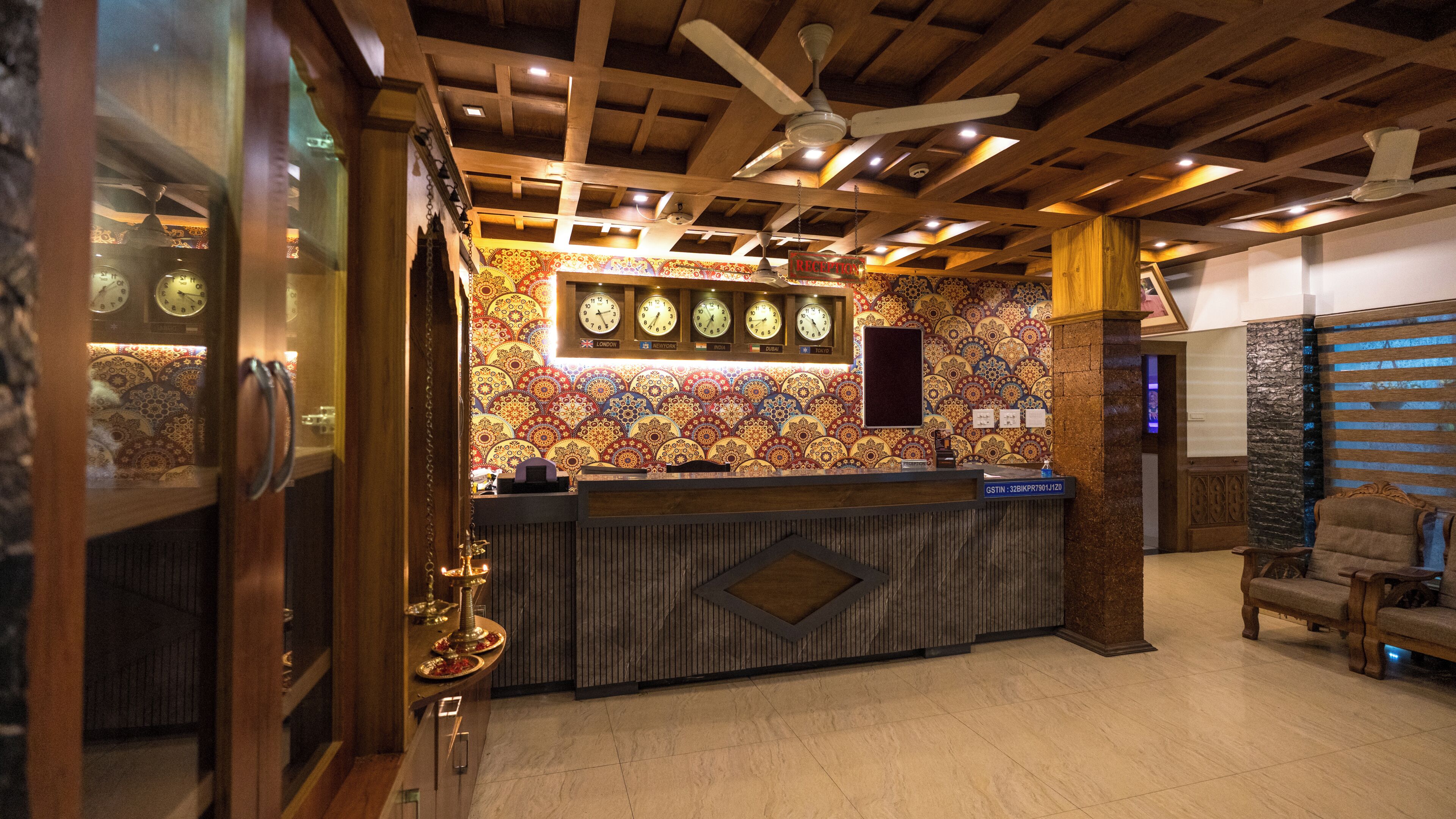 A reception area with a wooden ceiling, patterned wall, and a reception desk.