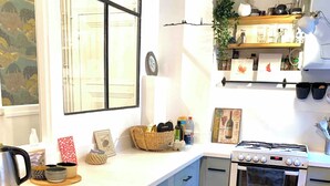 Een moderne keuken met een ingebouwde oven, een wit aanrecht en een houten vloer.
