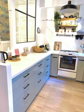Eine moderne Küche mit Einbauofen, weißer Arbeitsplatte und Holzboden.
