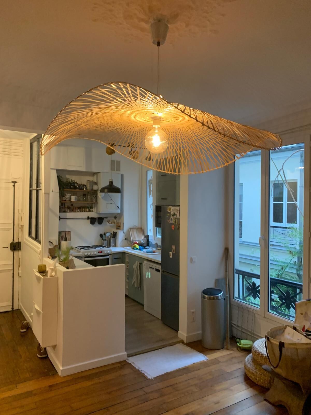 A modern kitchen with white cabinetry, a central island, and a hanging light fixture.